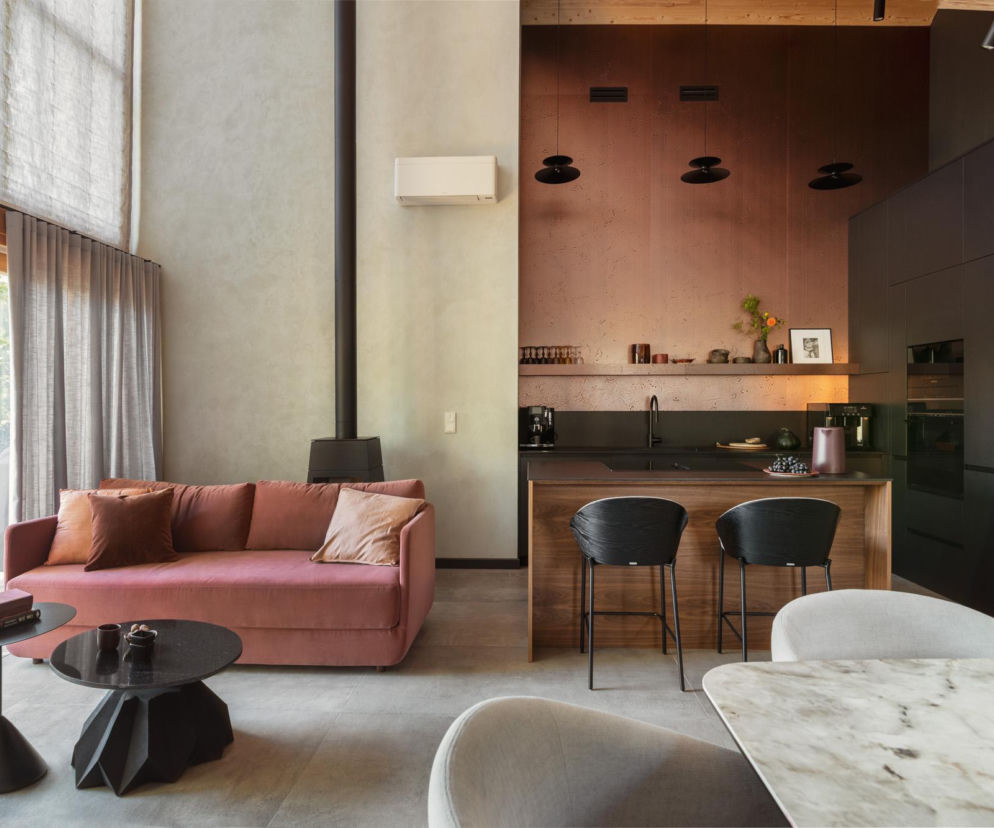 Kominek, beton, miedź i… pudrowy róż. Eklektyczny dom na Mazurach