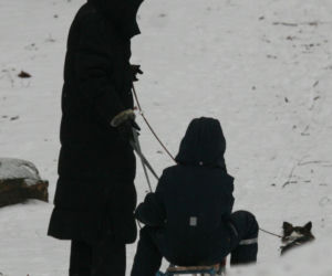 Marta Kaczyńska z synem i psami na sankach w lesie