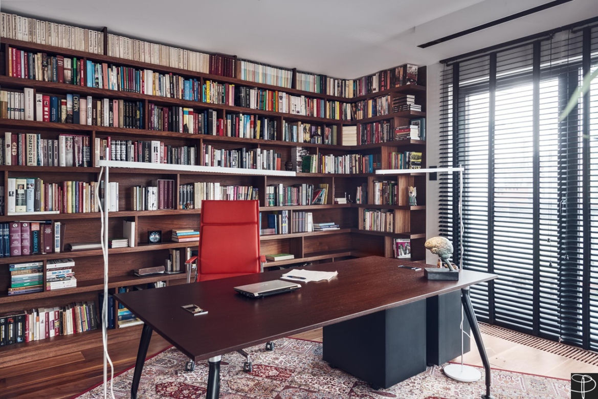 Lekkie, nowoczesne biurko na tle biblioteki w wielkomiejskim gabinecie