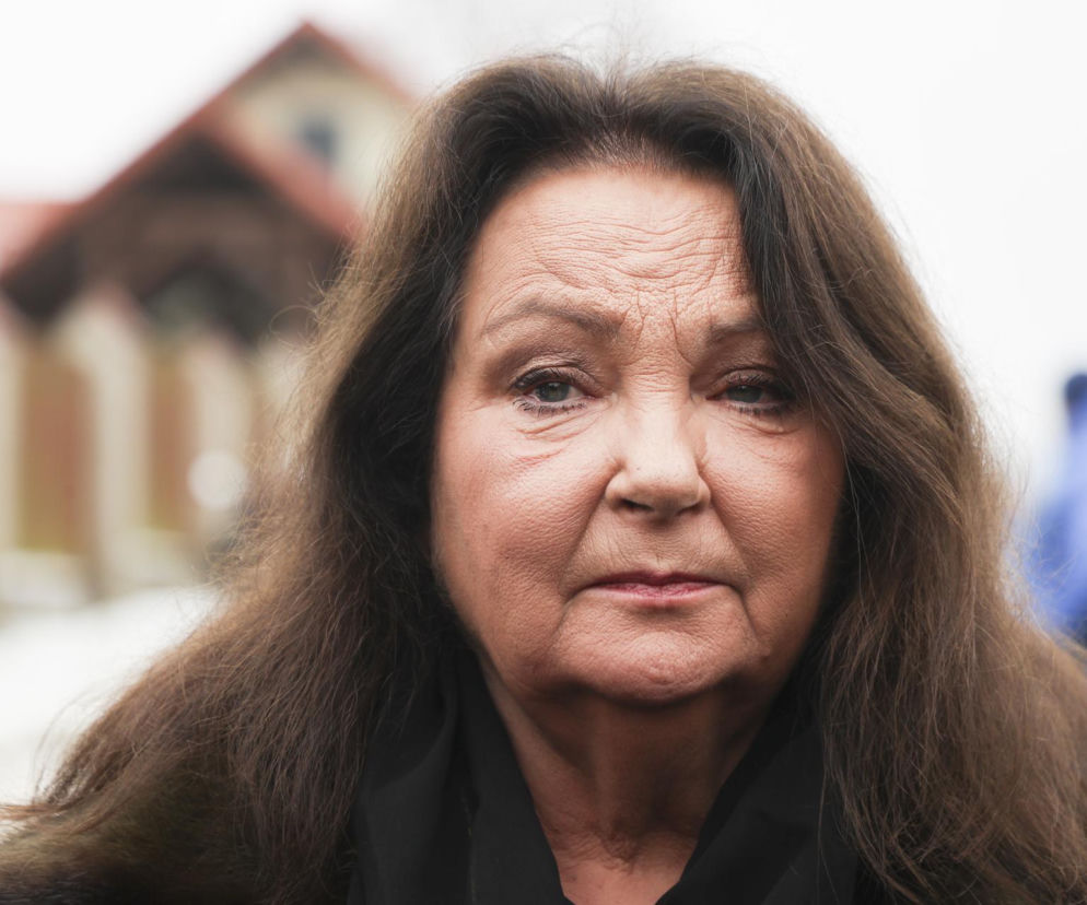 Aktorka Anna Dymna w czarnym ubraniu na tle rozmazanego budynku. O jej wysokiej emeryturze przeczytasz w Eska.