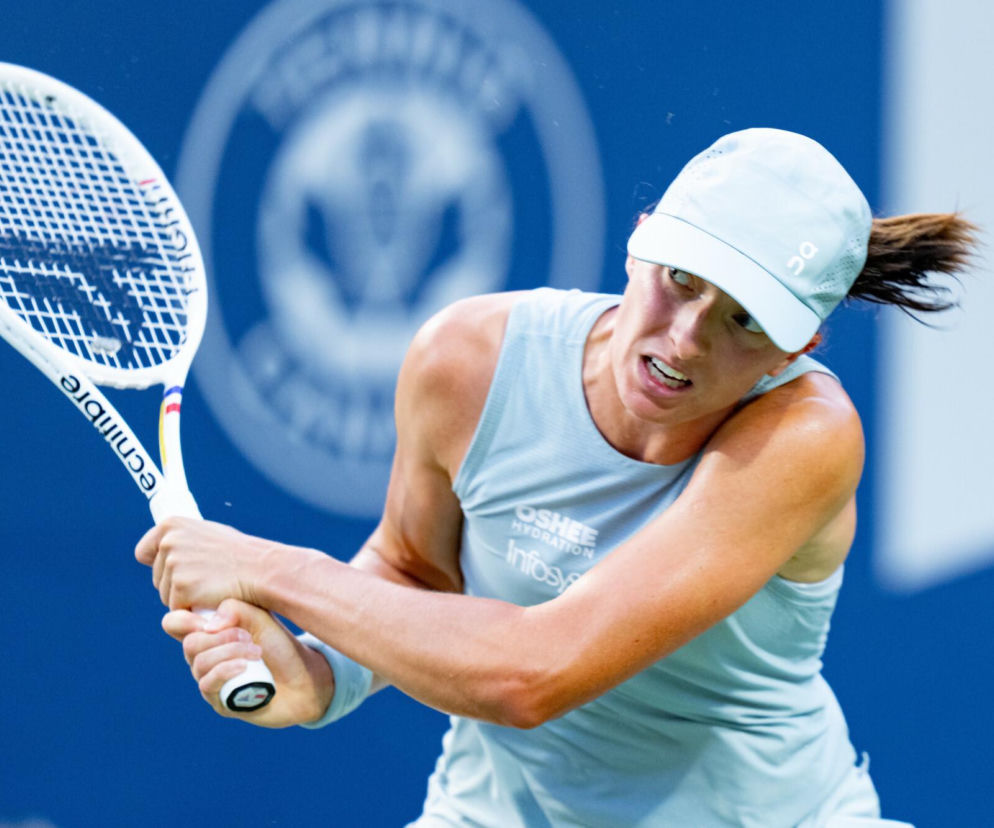 Skupiona Iga Świątek oburącz uderza rakietą w piłkę podczas US Open. Relację z turnieju znajdziesz w SE Supersport.