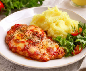 Schabowe zapiekane z pomidorami i serem. Mozzarella i parmezan zmieniają je w obiad po włosku