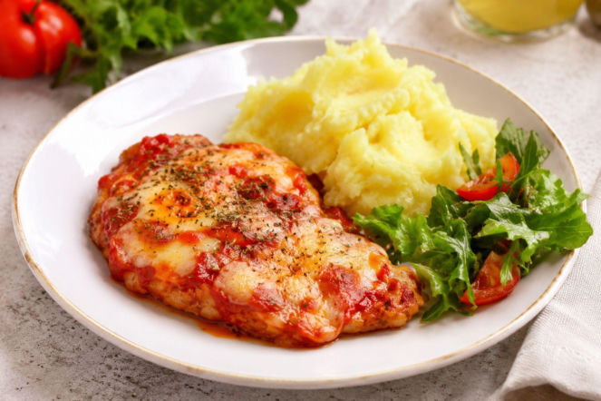 Schabowe zapiekane z pomidorami i serem. Mozzarella i parmezan zmieniają je w obiad po włosku