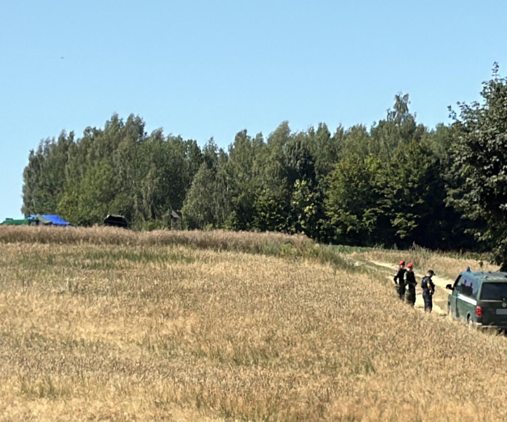 Służby przy samochodzie terenowym na skraju pola i lasu. O upadku rakiety w Tarnawie Kolonii przeczytasz na SE Lublin.