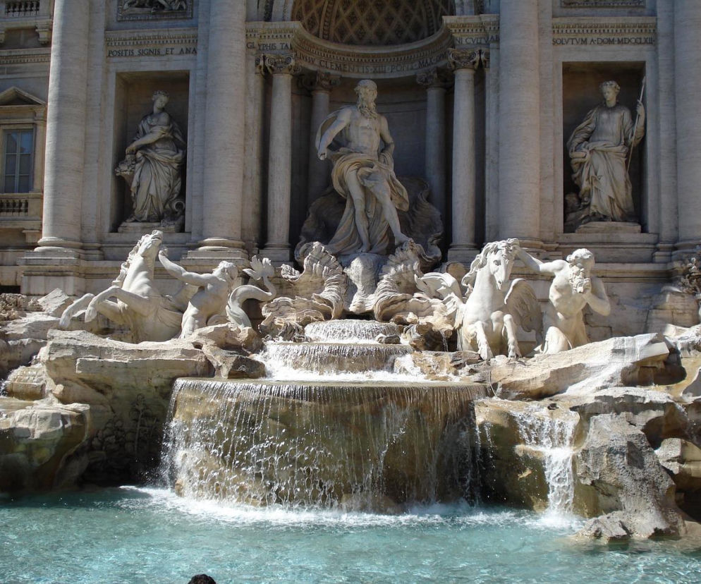 Słynna Fontanna di Trevi w Rzymie, ukazana w pełnej krasie z rzeźbami na tle pałacowej fasady, z turkusową wodą i kaskadami. Na Super Biznes przeczytasz o wprowadzeniu opłat za wstęp do tej popularnej atrakcji turystycznej.