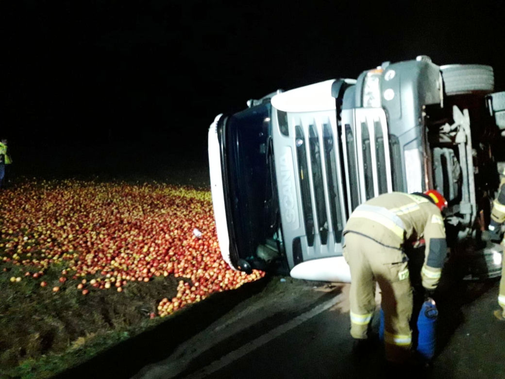 Tir przewożący jabłka wylądował na boku. Towar wysypał się na łąkę