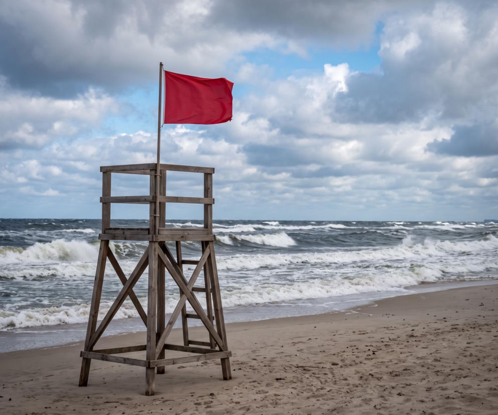 Czerwona flaga na wieży ratowniczej przy wzburzonym morzu. O zamkniętych plażach w Sarbinowie przeczytasz na SE Szczecin.