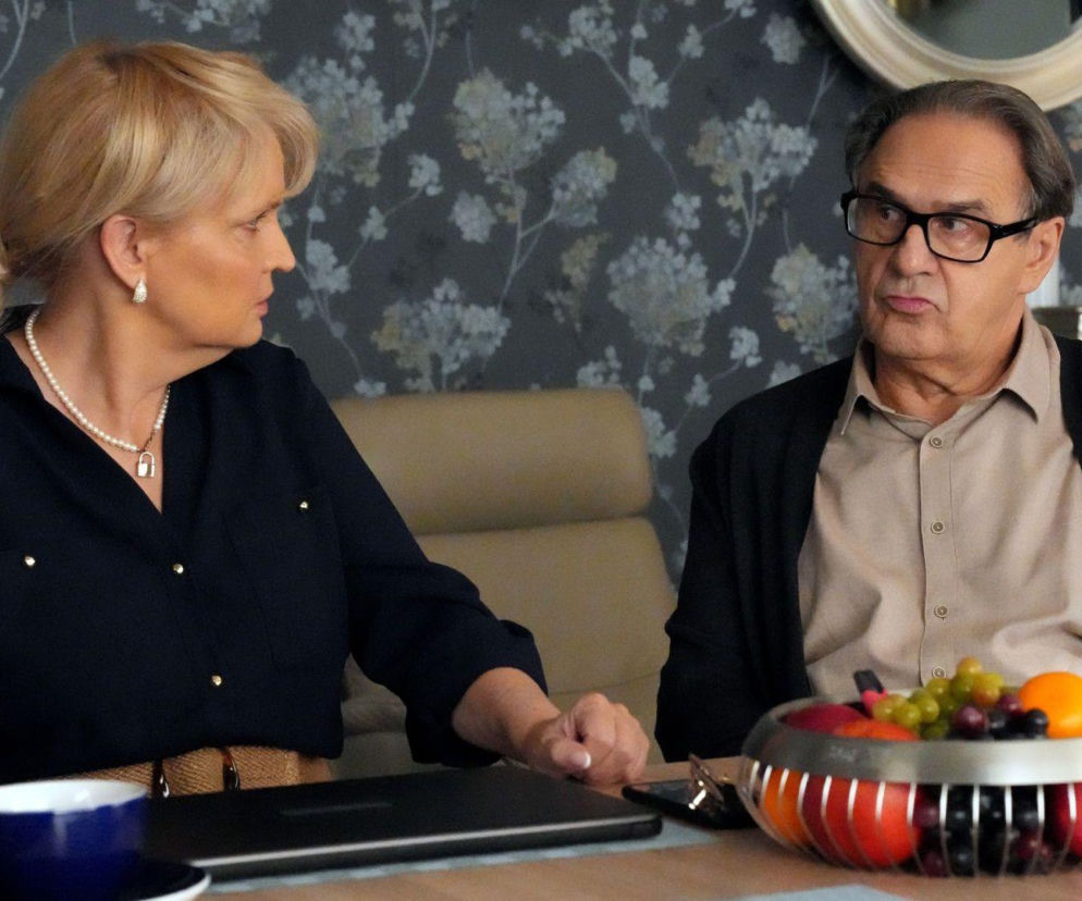 Małgorzata (Adrianna Biedrzyńska) i Jerzy (Bronisław Wrocławski) z Barw szczęścia siedzą przy stole, Małgorzata patrzy w prawo, Jerzy spogląda w lewo z wyraźnie niezadowoloną miną, rozmawiając o ultimatum. Więcej informacji o Super Seriale znajdziesz na naszym portalu.