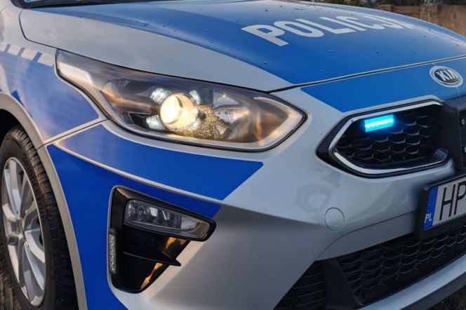 Zbliżenie na przód radiowozu policji z włączonymi światłami. O zatrzymaniu agresora w Częstochowie przeczytasz na SE.