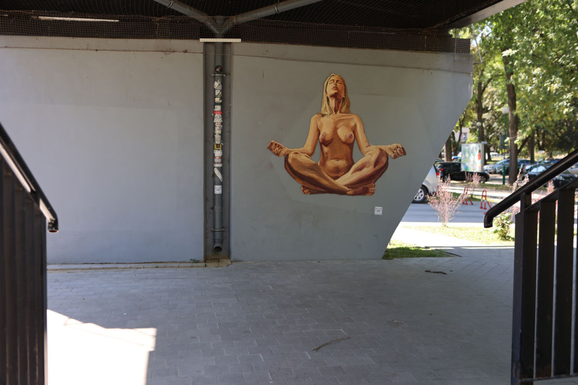 Naga kobieta uprawia jogę. Street art Lubliun