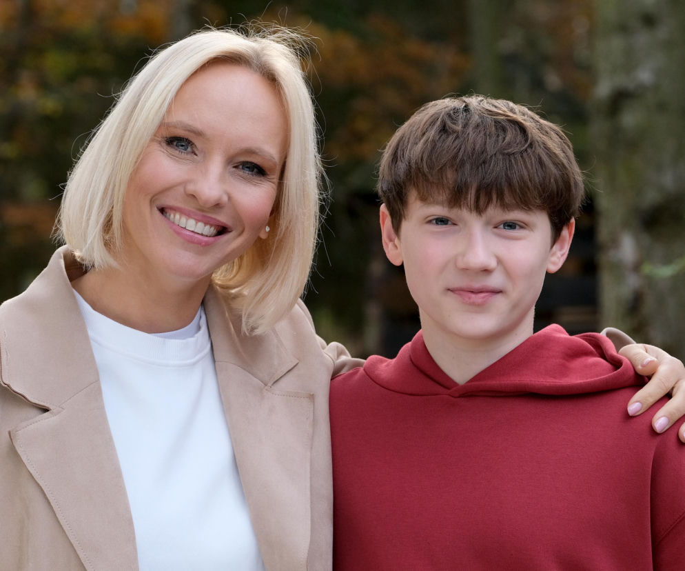 Uśmiechnięta Dorota (Iwona Rejzner) z jasnymi włosami obejmuje ramieniem Franka (Jarosław Śmigielski) w bordowej bluzie. Oboje patrzą w obiektyw. Zdjęcie ilustruje relacje bohaterów serialu M jak miłość. Więcej o losach Franka przeczytasz na Super Seriale.