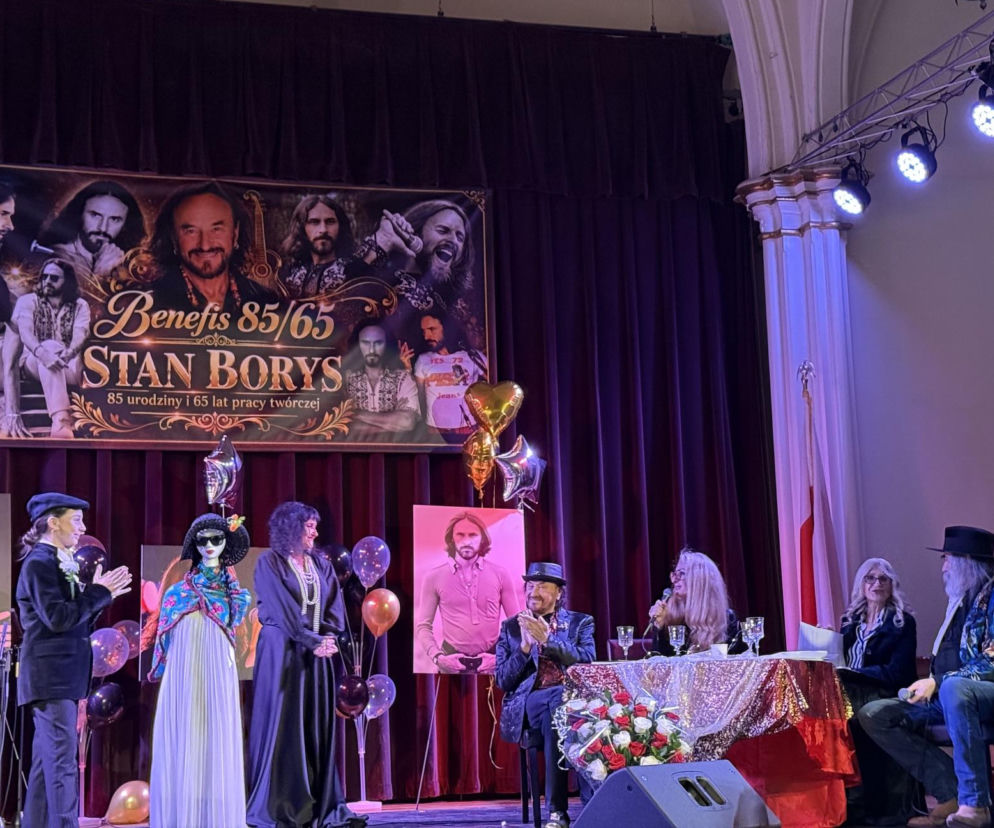 Stan Borys podczas swojego benefisu w Nowym Jorku siedzi przy stole na scenie. O jubileuszu artysty przeczytasz na SE USA.