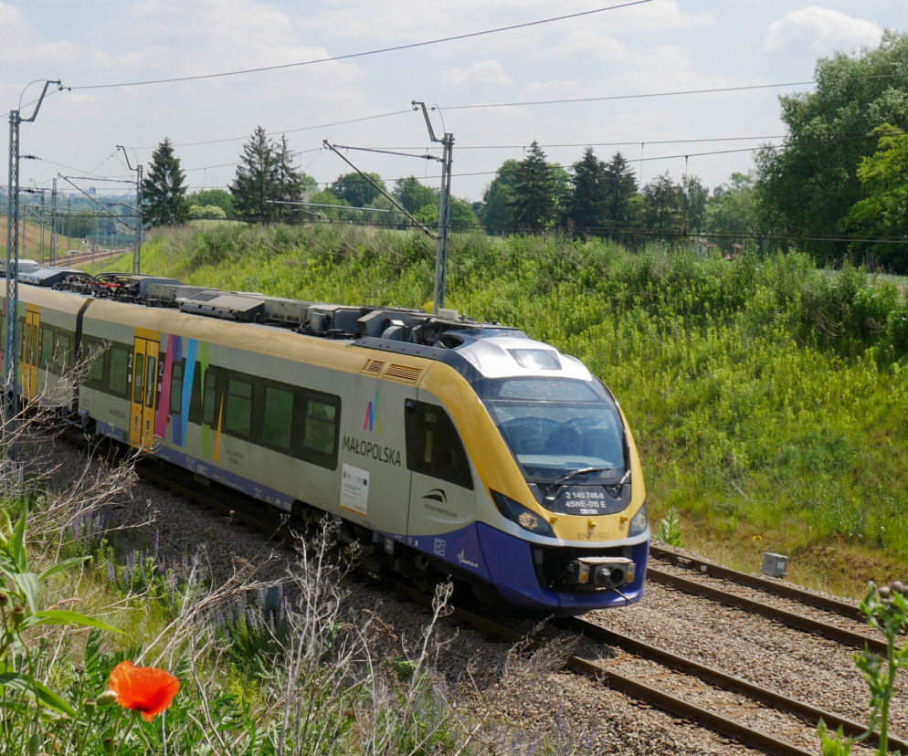 Pociąg Kolei Małopolskich jadący przez zielone tereny. O miliardowych inwestycjach w regionie przeczytasz na SE.