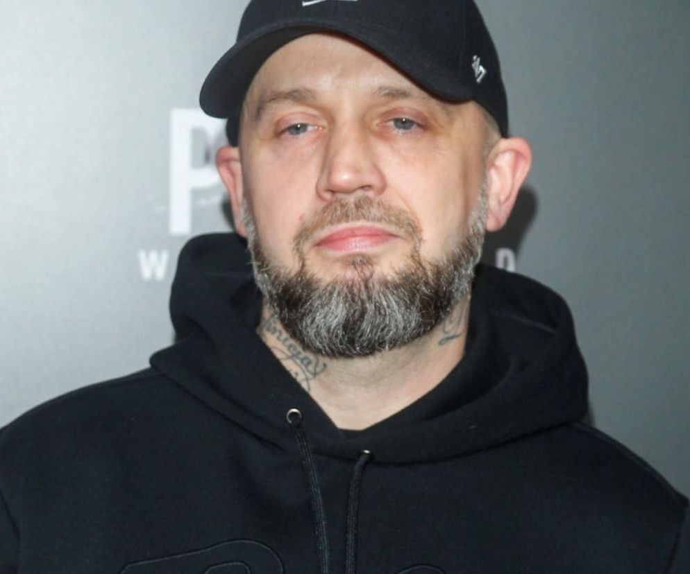 Raper Peja w czarnej bluzie z kapturem i czapce z daszkiem. O trasie koncertowej artysty przeczytasz w serwisie Eska.