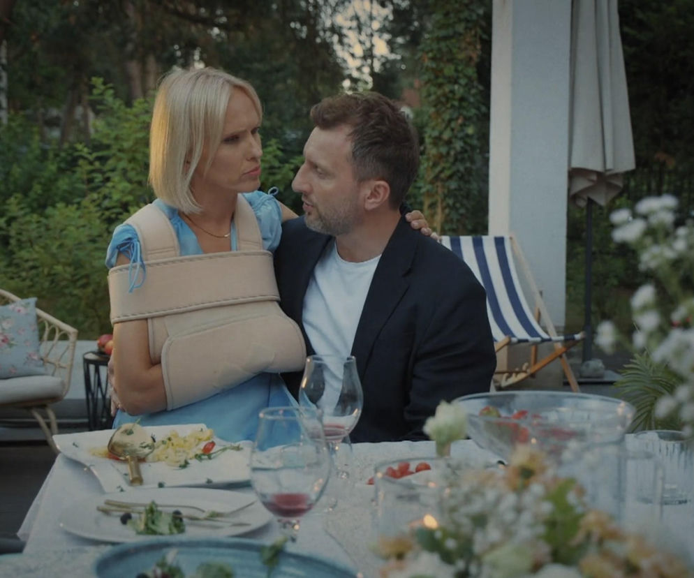 Dorota (Iwona Rejzner) z zabandażowaną ręką siedzi obok Bartka (Arkadiusz Smoleński) przy stole na zewnątrz domu. Para patrzy na siebie z troską. Na stole widać resztki jedzenia, świece i kwiaty. Artykuły o ich dalszych losach znajdziesz na stronie Super Seriale.