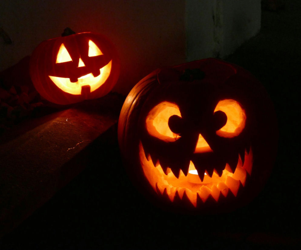Dwie wycięte i podświetlone dynie halloweenowe w ciemności. O Labiryncie Grozy w Galerii Młociny przeczytasz na SE.
