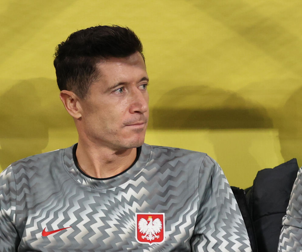 Robert Lewandowski w stroju treningowym reprezentacji Polski patrzy w bok. O burzy wokół piłkarza czytaj na SE Supersport.