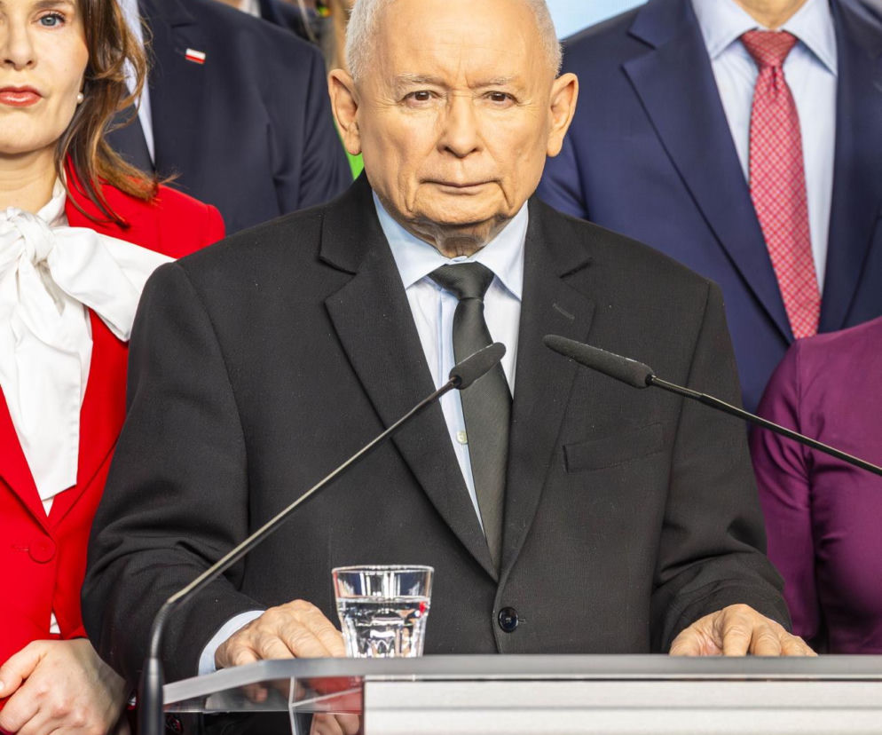 Jarosław Kaczyński, prezes PiS, stoi przy mównicy, za nim inni politycy, w tym Mateusz Morawiecki. Zdjęcie ilustruje temat usunięcia Janiny Goss z partii, o czym można przeczytać na naszym portalu.