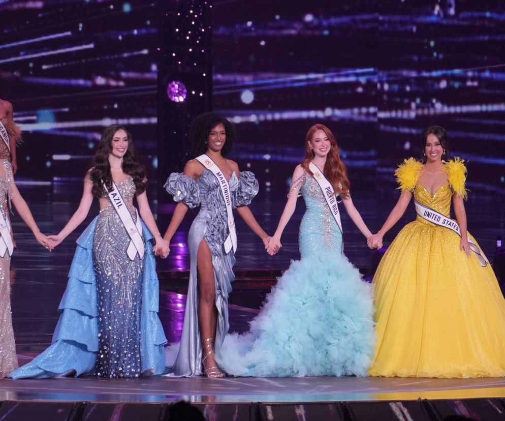 Pięć uśmiechniętych finalistek konkursu piękności w sukniach wieczorowych trzyma się za ręce. O Miss World 2026 czytaj w Eska.