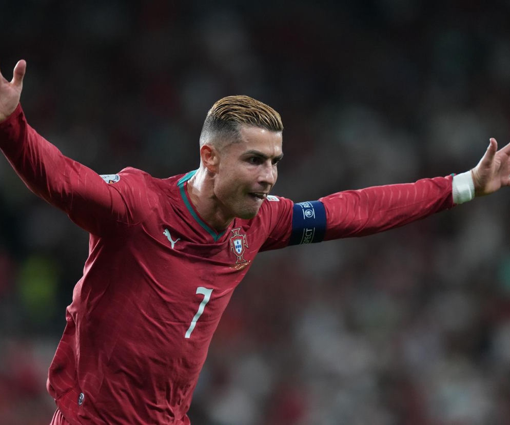 Cristiano Ronaldo w koszulce Portugalii z rozłożonymi rękami. O karze dla piłkarza przeczytasz na SE Supersport.