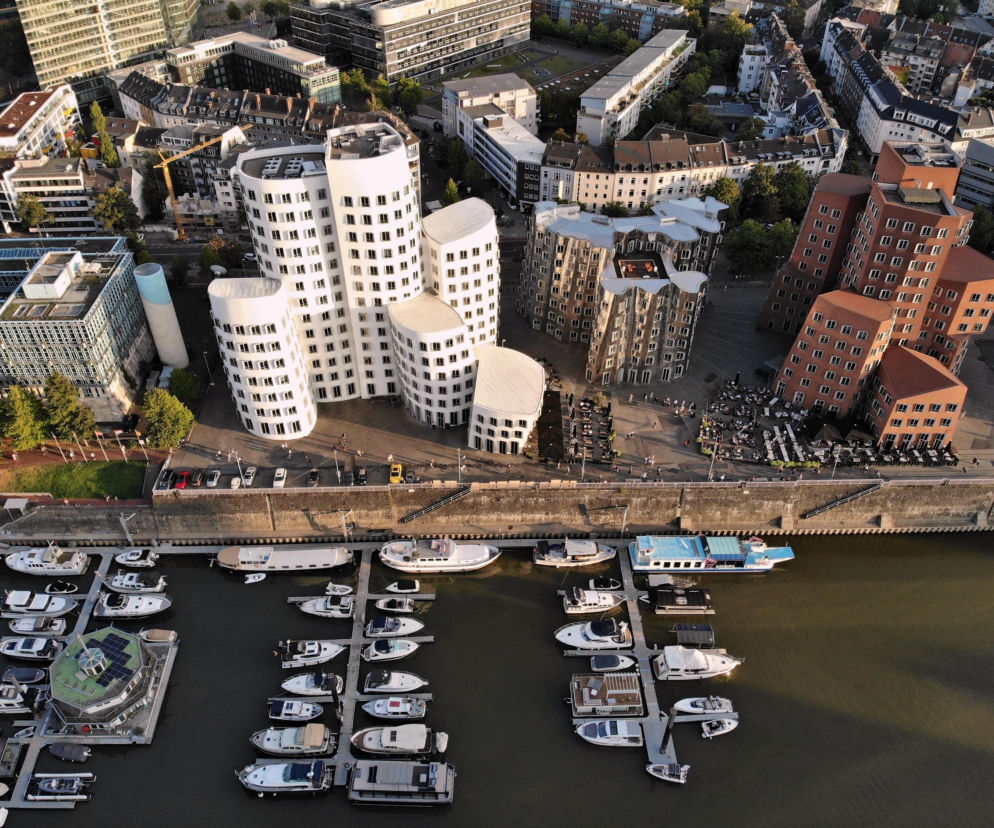 Trzy pofalowane budynki Neuer Zollhof nad nabrzeżem w Düsseldorfie. O ikonach architektury Gehry’ego przeczytasz na Architektura.
