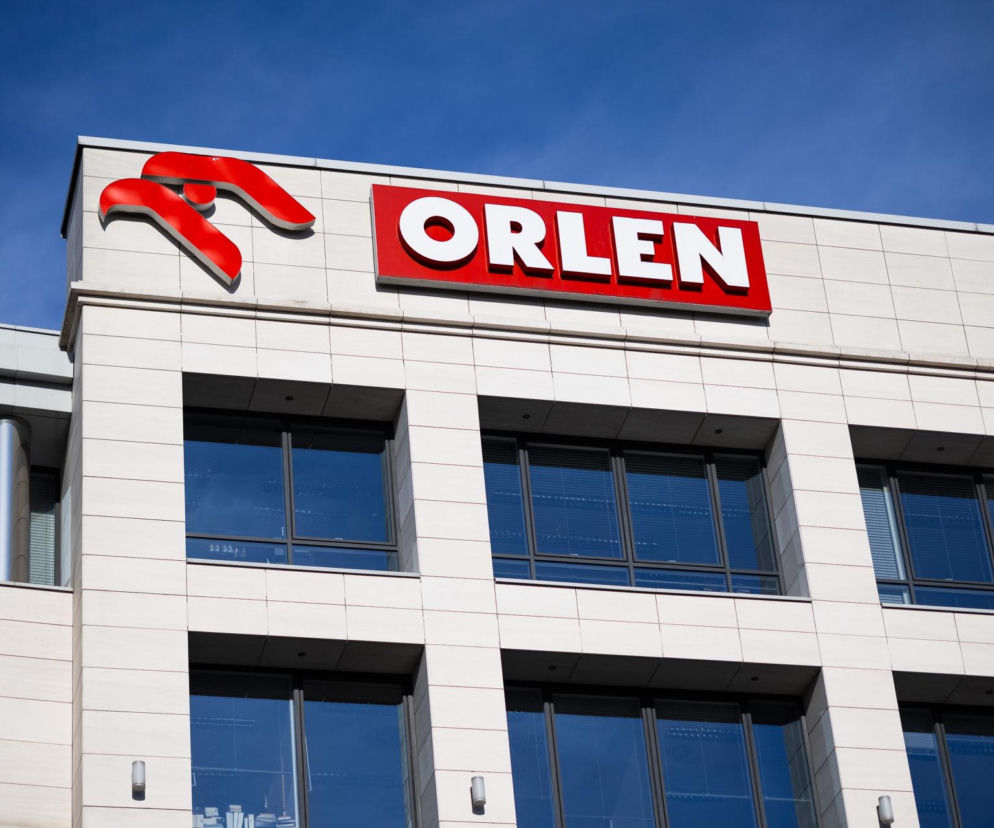 Budynek z logo Orlen na tle błękitnego nieba symbolizuje przejęcie kontroli nad instalacją butadienu od Synthos. Więcej o tej kluczowej transakcji i jej znaczeniu dla petrochemii przeczytasz na Super Biznes.