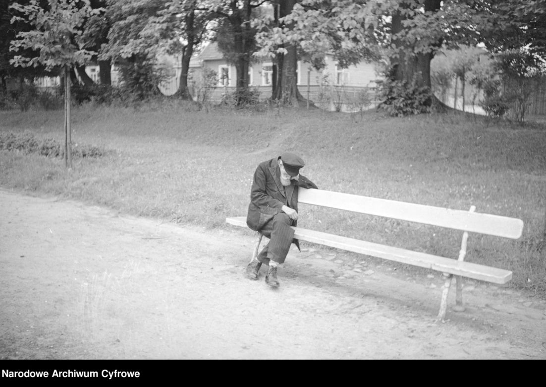 Starszy mężczyzna siedzący na ławce w alei parkowej. 1936 rok