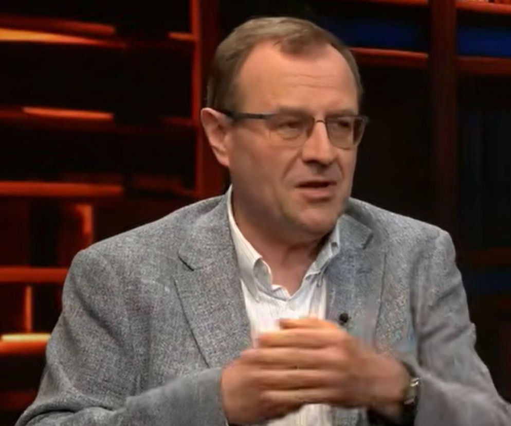 Profesor Antoni Dudek w szarej marynarce i okularach podczas nagrania. O jego analizie politycznej dowiesz się w Mediateka.