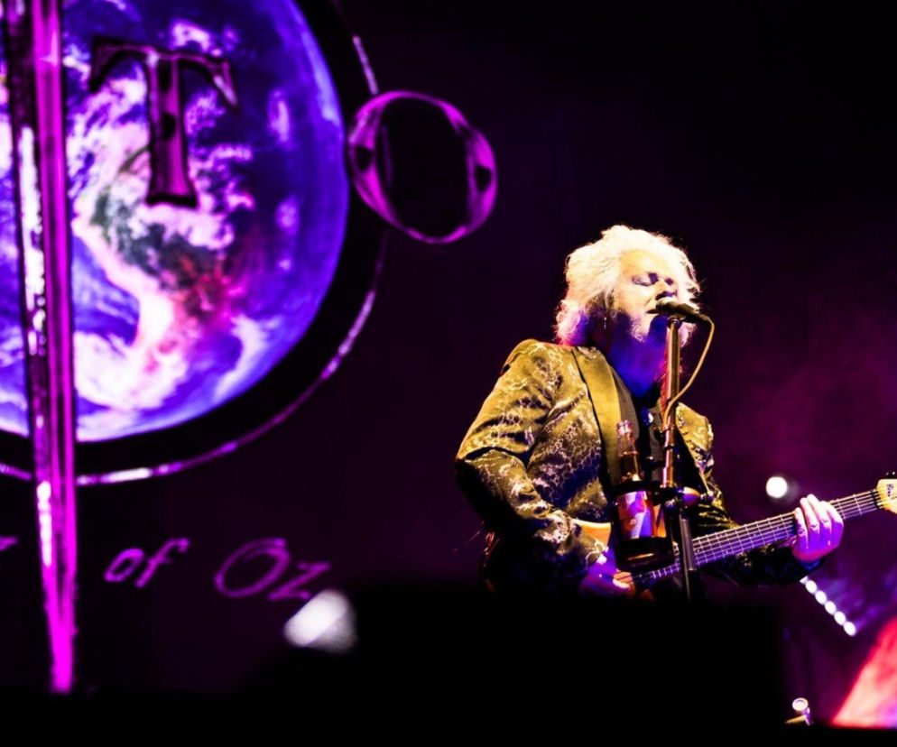 Steve Lukather gra na gitarze na scenie podczas koncertu Toto. O historii muzyka przeczytasz na EskaRock.