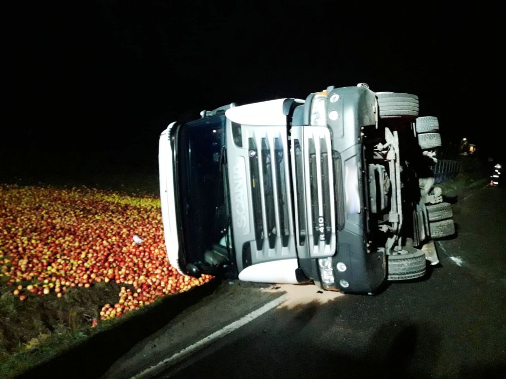 Tir przewożący jabłka wylądował na boku. Towar wysypał się na łąkę