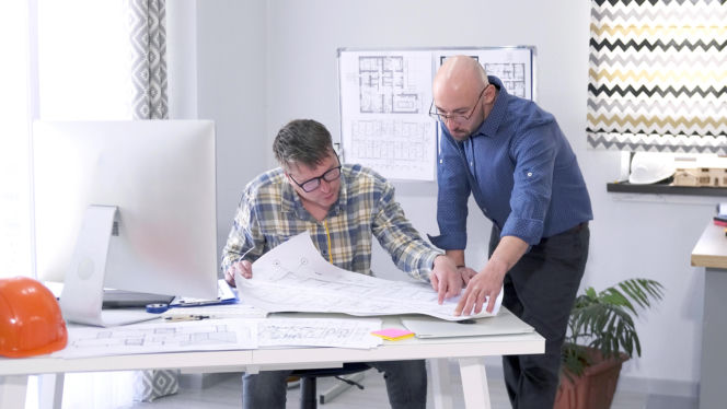 Architekci analizujący projekt budowlany w biurze projektowym