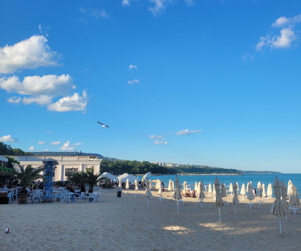 Piaszczysta plaża w Warnie z parasolami i kawiarnią nad brzegiem morza. O pamiątkach z Bułgarii przeczytasz na SE.