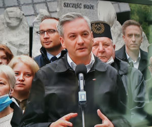 Robert Biedroń na tle religijnego hasła