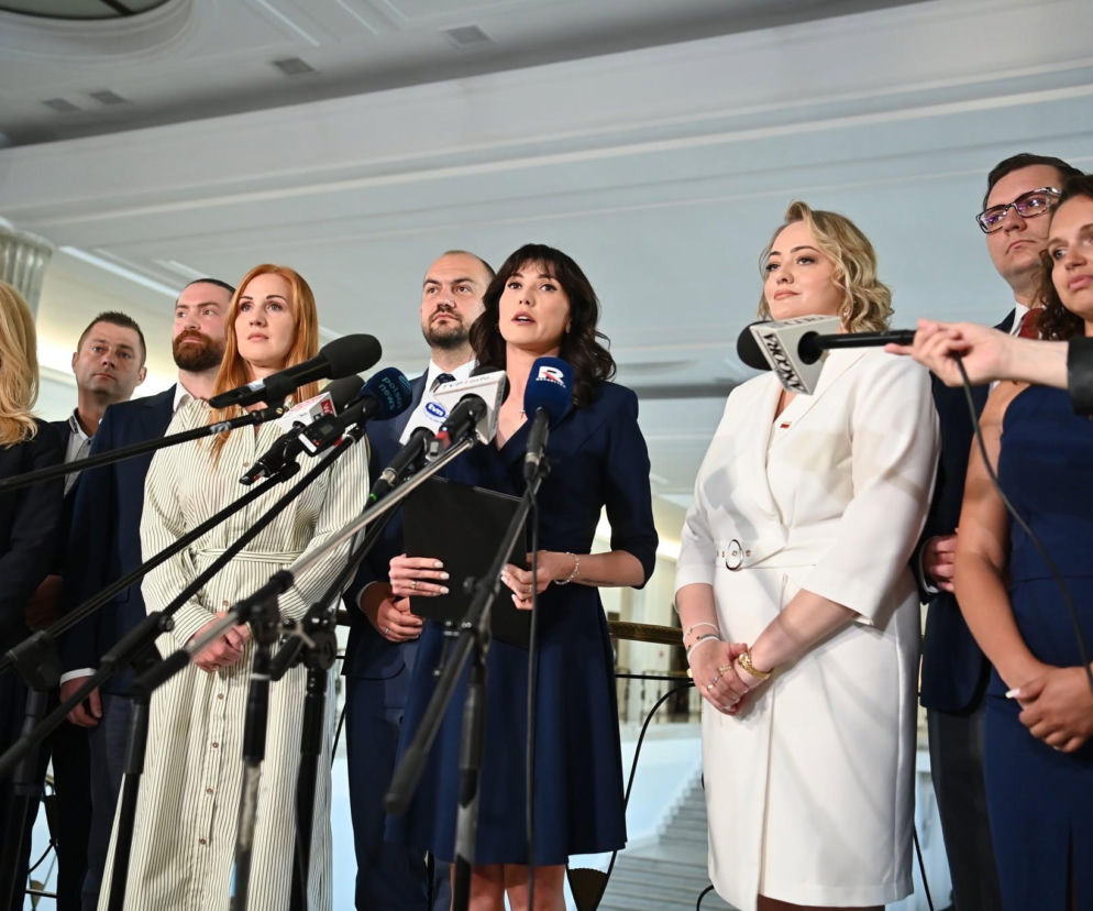 Ewa Zajączkowska-Hernik w granatowej sukience z mikrofonami na pierwszym planie, ogłaszająca powstanie Ruchu Biało-Czerwonych. Obok niej stoją inne osoby, część z nich również trzyma mikrofony. Na naszym portalu możesz przeczytać o celach i założeniach stowarzyszenia.