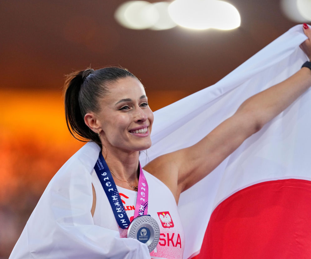 Uśmiechnięta biegaczka Natalia Bukowiecka ze srebrnym medalem i polską flagą. O Diamentowej Lidze przeczytasz na SE Supersport.