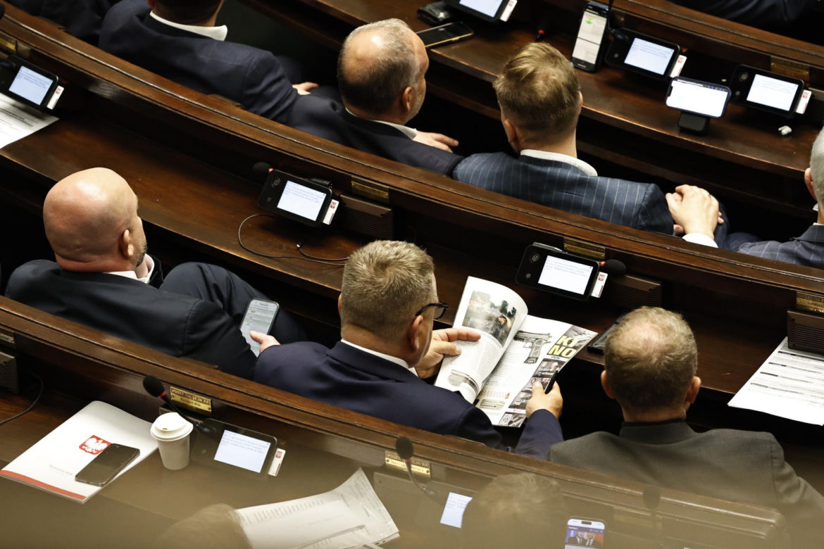 W  czasie obrad Sejmu poseł przeglądał katalog z bronią