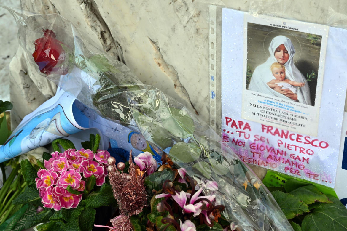 Wierni modlą się o zdrowie Franciszka przed pomnikiem Jana Pawła II. Składają kartki z życzeniami i wiązanki z białych róż