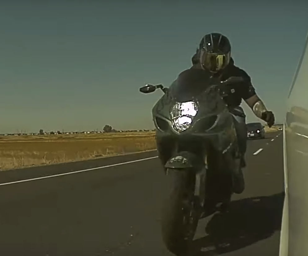 Wandal na motocyklu uderza w lusterko Tesli