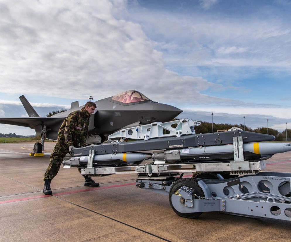 Żołnierz w mundurze polowym przygotowuje inteligentne bomby GBU-53/B StormBreaker do załadunku na myśliwiec F-35A Lightning II, co wzmacnia fińskie lotnictwo. Więcej o zakupie zaawansowanej amunicji przeczytasz na naszym portalu.