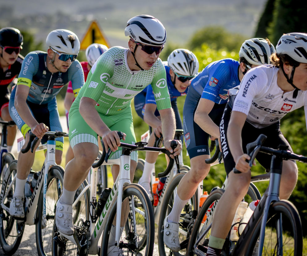 Grupa kolarzy w kaskach i profesjonalnych strojach podczas wyścigu. O wynikach VeloTalent Cycling Team przeczytasz na SE.
