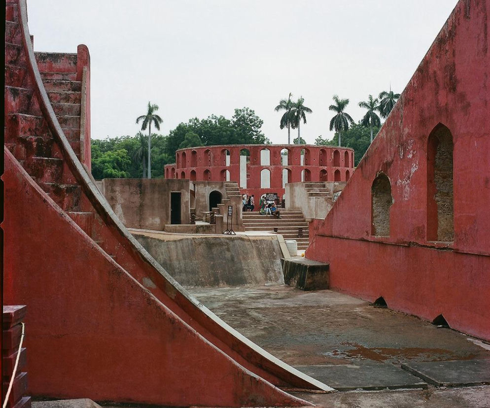 Panorama czerwono-ceglanych instrumentów astronomicznych Dźantar Mantar, z monumentalnymi schodami i łukowatymi otworami, ukazuje siłę architektury jako narzędzia poznania i zachwytu. Więcej o potędze architektury przeczytasz na Architektura Murator Plus.