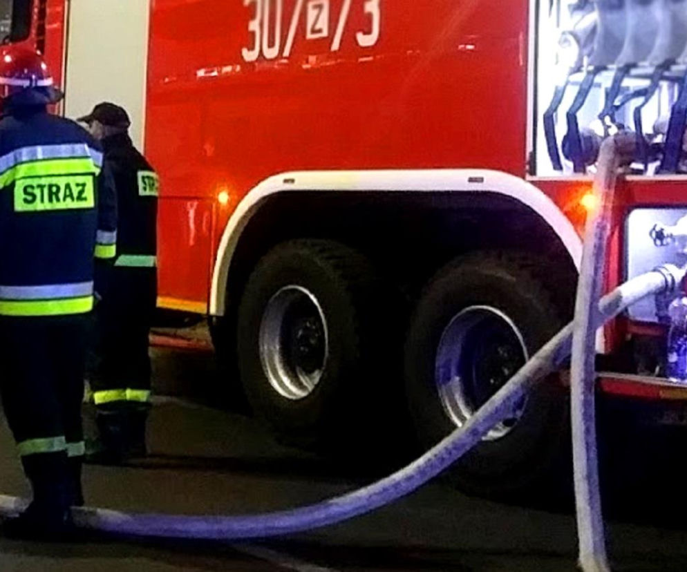 Strażak przy wozie gaśniczym podczas nocnej akcji. O pożarze domu dziecka w Pęcherach przeczytasz na SE.