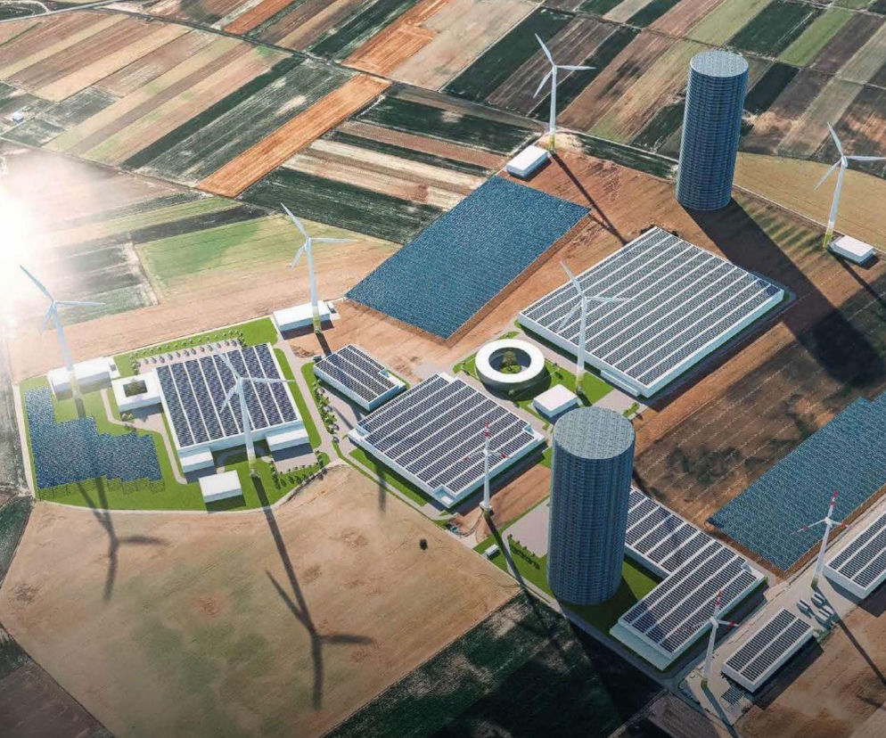 Dwie wysokie wieże i turbiny wiatrowe wśród pól uprawnych. O inwestycji w zielony wodór przeczytasz na SE Superbiz.