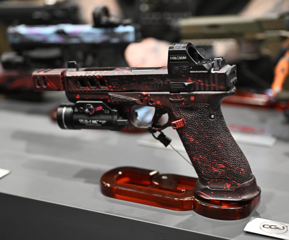 Pistolet Glock z kolimatorem w czerwono-czarne barwy. O debacie nad dostępem do broni przeczytasz na SE Portal Obronny.