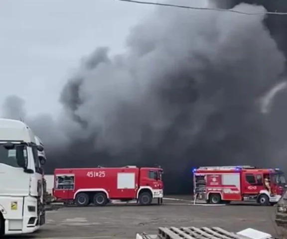 Płonie hala przemysłowa. Czarny dym nad miastem