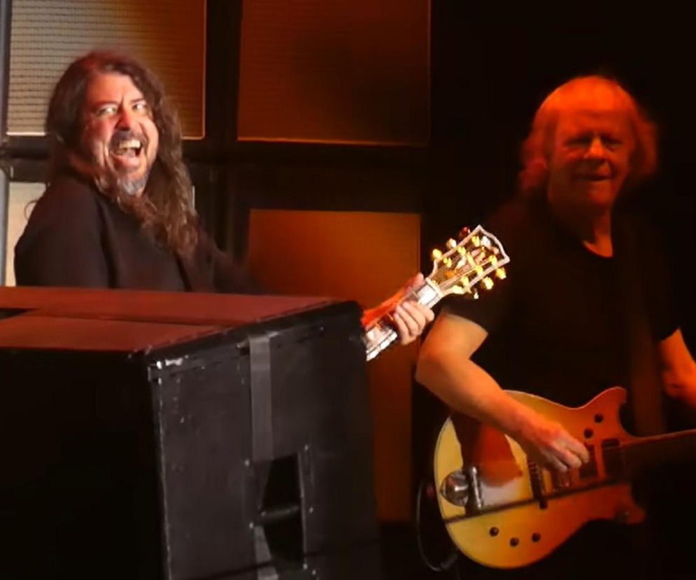 Uśmiechnięty Dave Grohl i Angus Young z AC/DC grają na gitarach. O finale trasy Power Up World Tour czytaj w EskaRock.