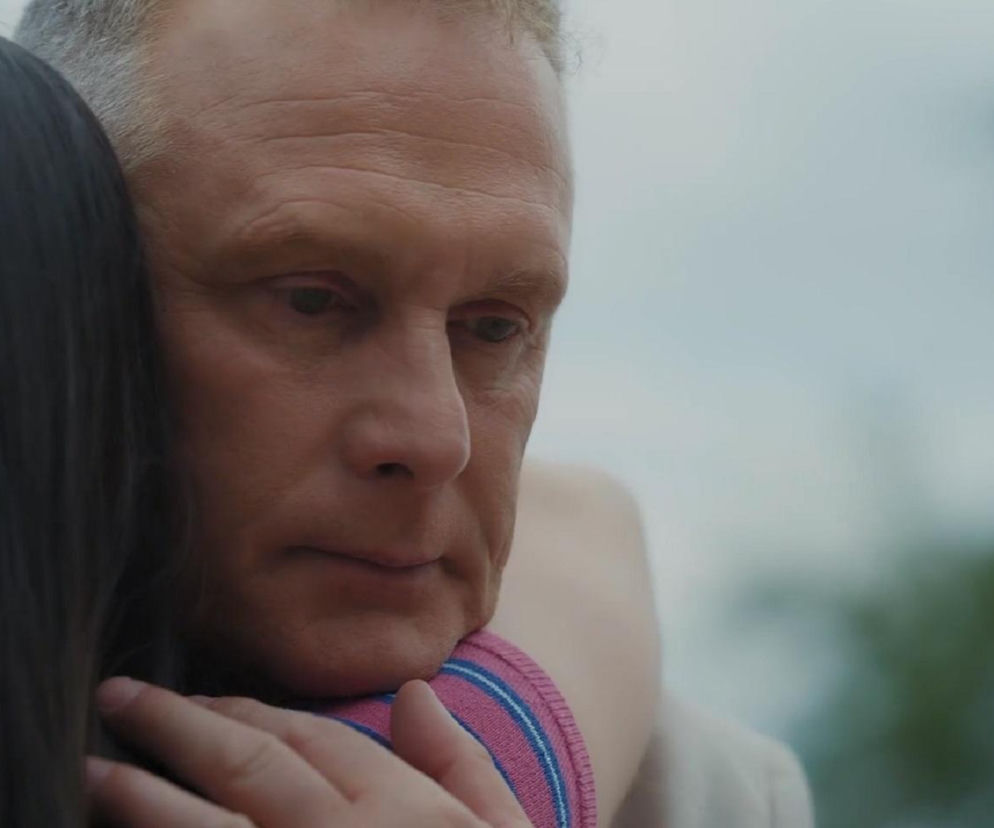 Artur Rogowski (Robert Moskwa) ze smutkiem na twarzy, ze spuszczonym wzrokiem, przytula Basię (Karina Woźniak) w dramatycznej scenie z serialu M jak miłość. Tę i inne wzruszające historie z ulubionych seriali znajdziesz na portalu Super Seriale.