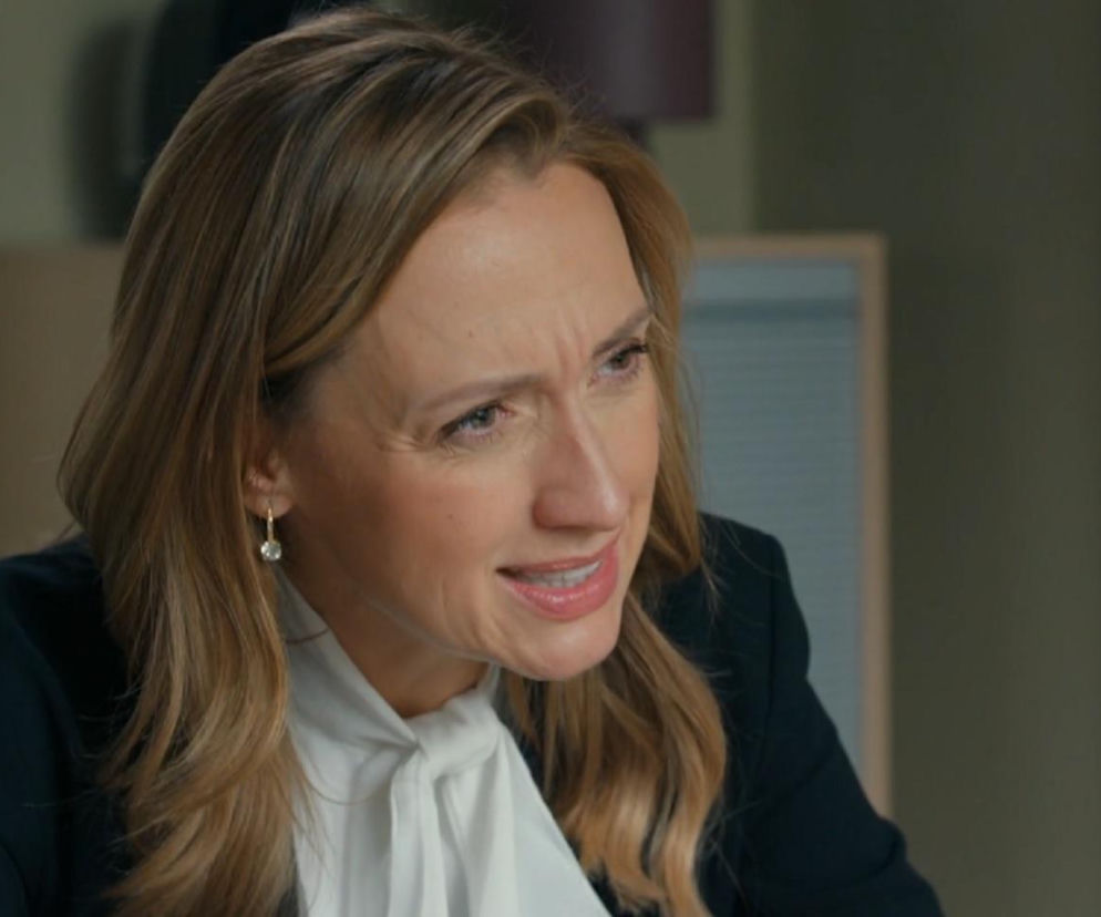 Aktorka Marta Juras jako Gabrysia Niedzielska z serialu Barwy szczęścia z wyrazem zmartwienia, widoczna od ramion w górę, w czarnej marynarce i białej bluzce z kokardą. Jej cera jest jasna, a włosy blond, lekko falowane, z przedziałkiem na bok. Twarz wyraża zaniepokojenie, zmarszczone brwi, co odzwierciedla emocjonalny kontekst artykułu dotyczącego serialu Barwy szczęścia. Więcej o tym na Super Seriale.