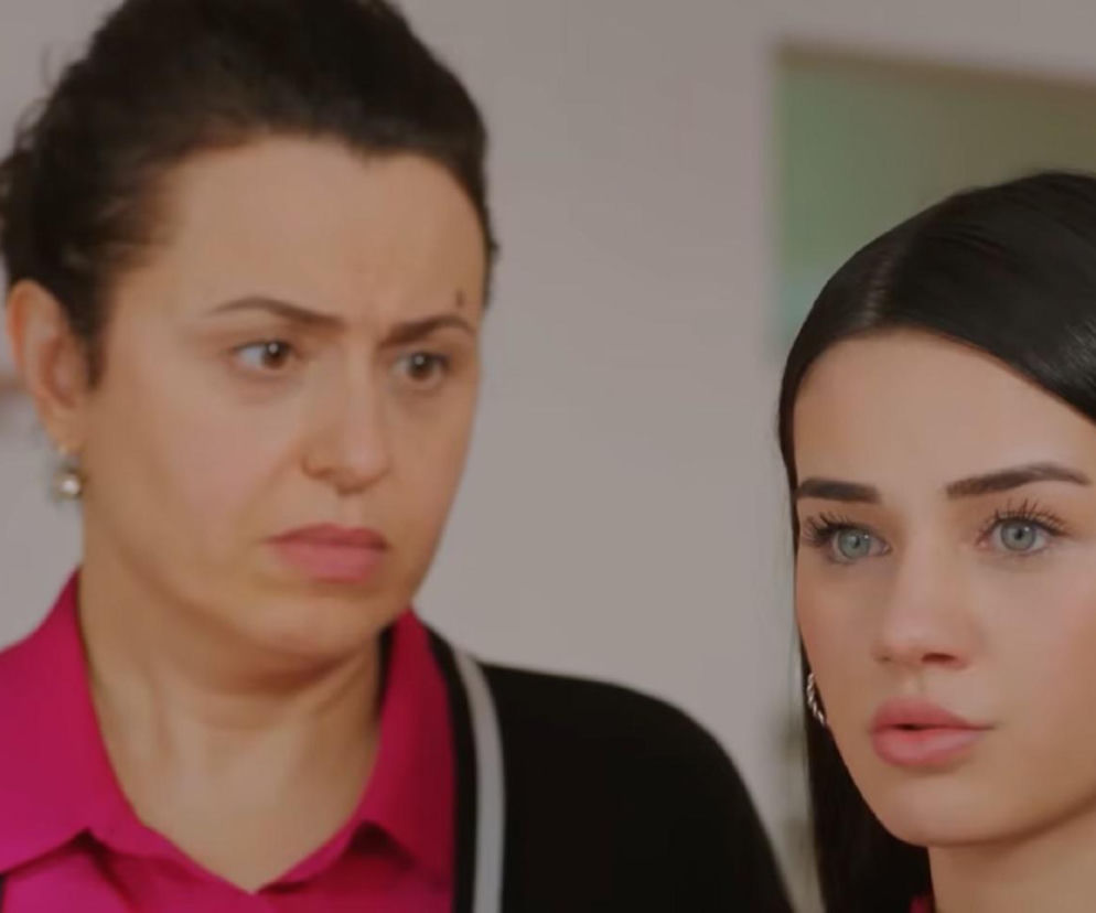 Bahar i Cavidan na zbliżeniu w kadrze z serialu „Miłość i nadzieja”. Bahar ma długie ciemne włosy, duże niebieskie oczy i różowe usta, na szyi widoczny jest sznur pereł. Cavidan w tle patrzy na nią z dezaprobatą, co oddaje intrygę Bahar z 353 odcinka serialu. Więcej o ich planach przeczytasz na Super Seriale.