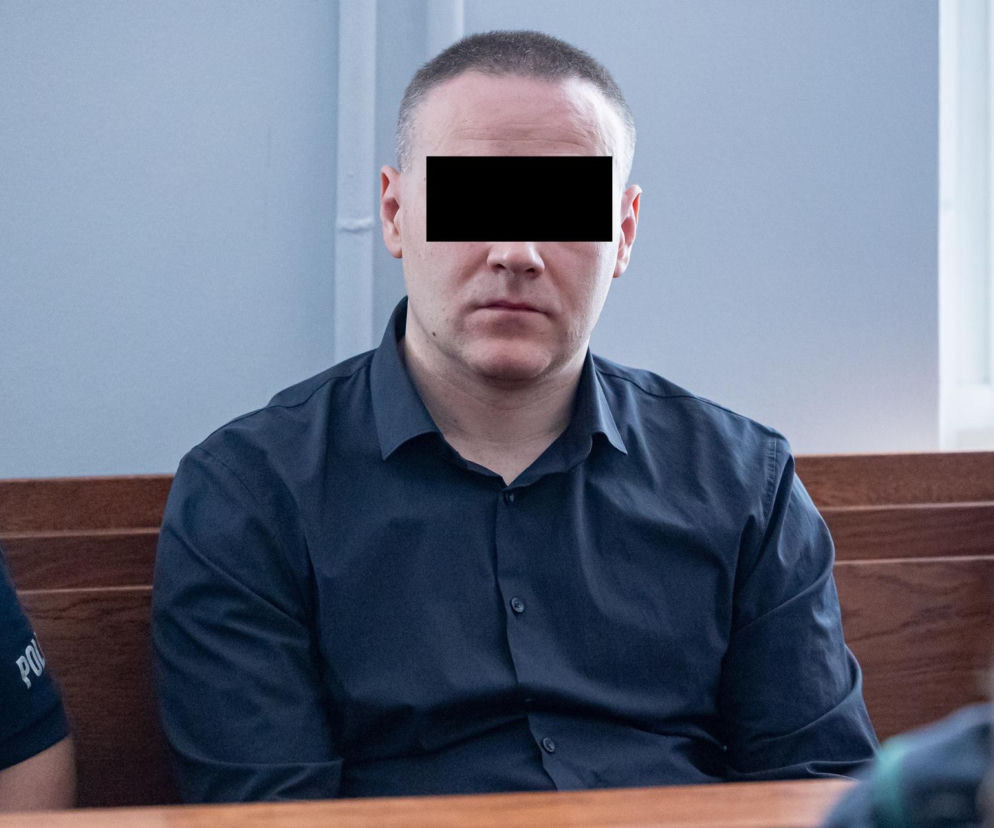 Jarosław S., oskarżony o brutalne zabójstwo Natalii K. w Poznaniu, siedzi w sądzie podczas procesu. Mężczyzna, którego twarz jest ocenzurowana, ubrany w ciemną koszulę, wydaje się zamyślony. O sprawie i szczegółach tej szokującej zbrodni przeczytasz więcej na naszym portalu.